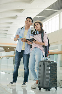 有行李箱的年轻夫妇在机场候图片