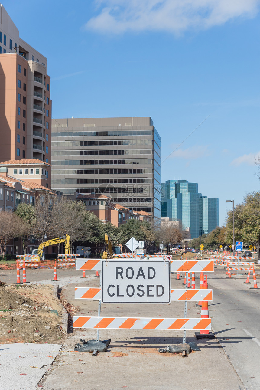 美国德克萨斯州欧文市中心在云蓝天下的道路封闭标志背景中的路障封闭带有建筑设备的锥图片