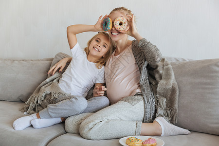 母亲和女儿用甜圈遮着眼睛眼罩图片