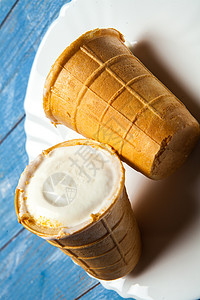 华夫饼干杯中的冰淇淋勺白色木头和蓝色背景上的华夫饼冰淇淋华夫饼碗里图片