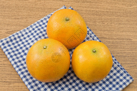 木质桌上的三颗里普和甜橘子橙色是柑橘图片