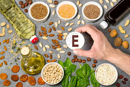 富含维生素E的食物维生素的各种天然来源有益于健康和均衡饮食的物预防维生素缺乏症人的手握着带有维生素E名称的背景图片