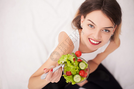 美丽的吃蔬菜的女青年图片
