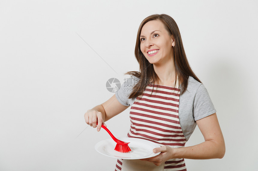 美丽的女管家用红色刷子洗白盘子图片