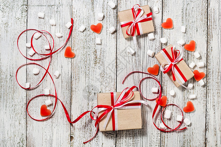 情人节糖果心棉花糖和一盒礼物在白木背景的图片