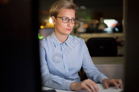戴眼镜的集中年经理的腰部肖像坐在办公桌前并在计算机的帮助下分析完图片