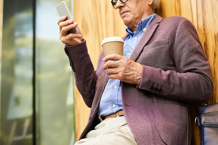 利用现代智能户外智能手机为当代老年男子提供图片