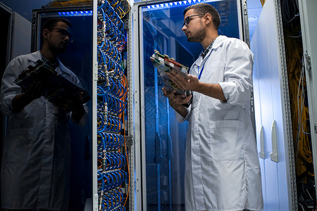 青年男子在为科学目的与超级计算机合作时背景图片
