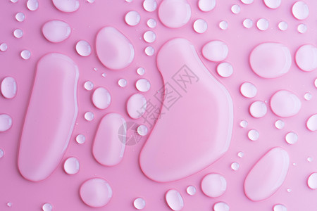 粉红色背景上的水滴图片