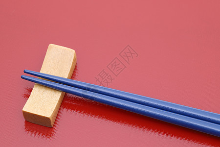 筷子和筷子搁在红桌背景上图片