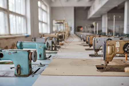 废弃服装厂的旧缝纫机背景图片
