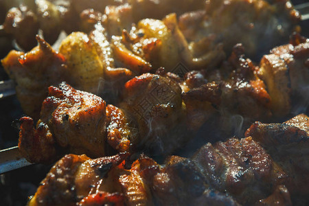 街头快餐节在金属串特写上烹饪生烤肉串烧烤新鲜牛扒切片传统的东方菜肴图片