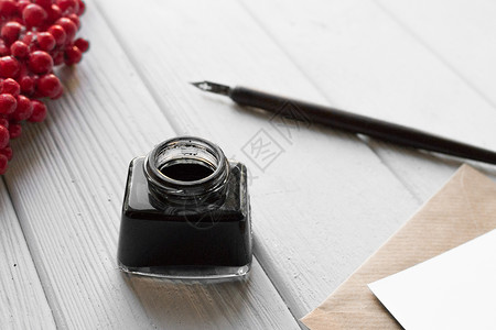 白色木桌上的一套老式蘸笔墨水瓶带信封和红高清图片