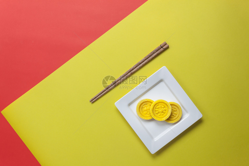 布置装饰新年和农历节日概念背景的顶视图用木筷子在盘子里放上季节的甜点办公桌上现代黄色和红图片