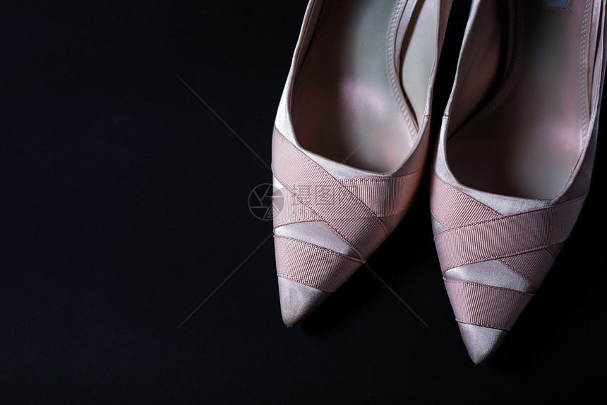 黑色背景上的时尚女粉色鞋子图片
