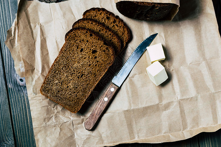 深色背景中的黑面包刀和油片图片