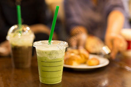 绿茶和冰果可在模糊背景的塑料图片