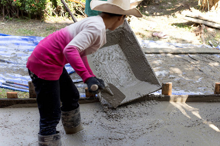 建筑工地混凝土地板中的女建筑工人图片