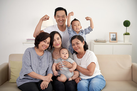 大亚洲家族的肖像在家中摆相片图片
