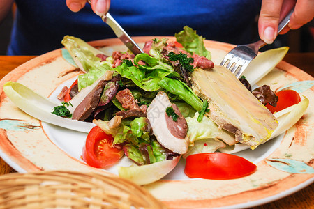 访问者在诺曼底的埃特雷塔特镇餐厅与典型的当地诺曼肉食开胃图片
