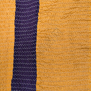 缝制围巾从缝合丝织物条纹的黄色纺织品背图片