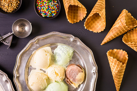 华夫冰淇淋甜筒盘子上放着一盘冰淇淋勺图片