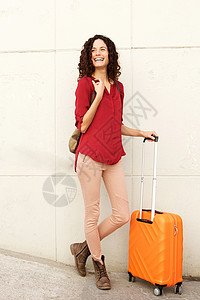带着手提箱站着的年轻旅行女青年图片