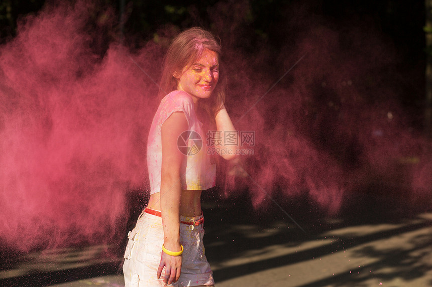 年轻美女玩粉红干油漆霍利图片