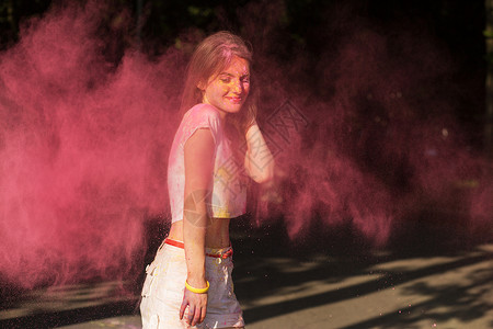 年轻美女玩粉红干油漆霍利图片