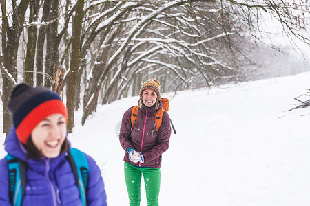 朋友们玩雪球妇女们在冬天的森林里散步女孩们在冬季比赛中在雪地公园度图片