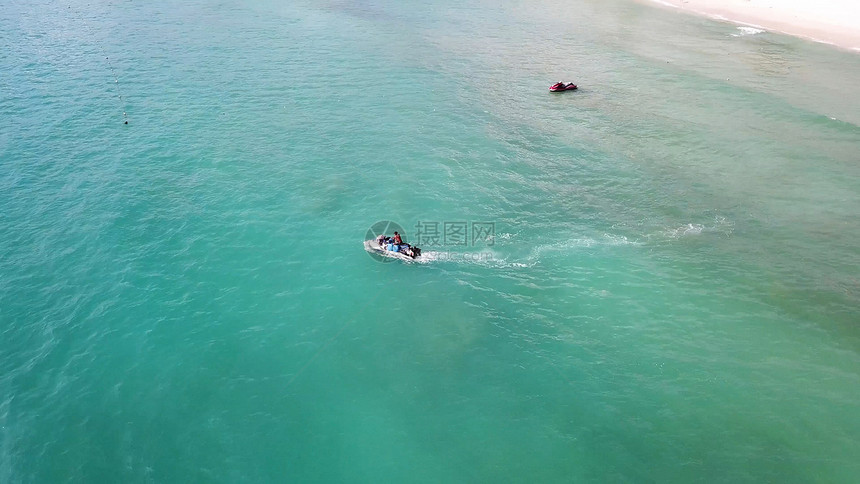 白色沙滩和水上摩托艇在蓝色泻湖水上的鸟瞰图在绿松石清澈的海水中高速巡航的喷气式滑图片