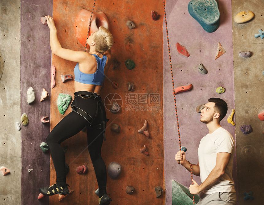女健身专业运动登山者在抱石健身房接受训练图片