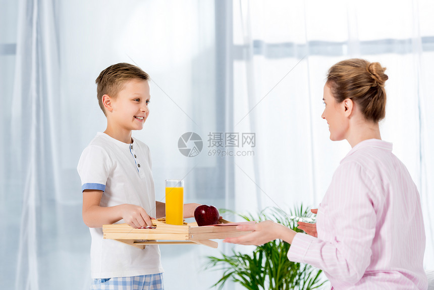 快乐的小儿子带着早餐在木托图片