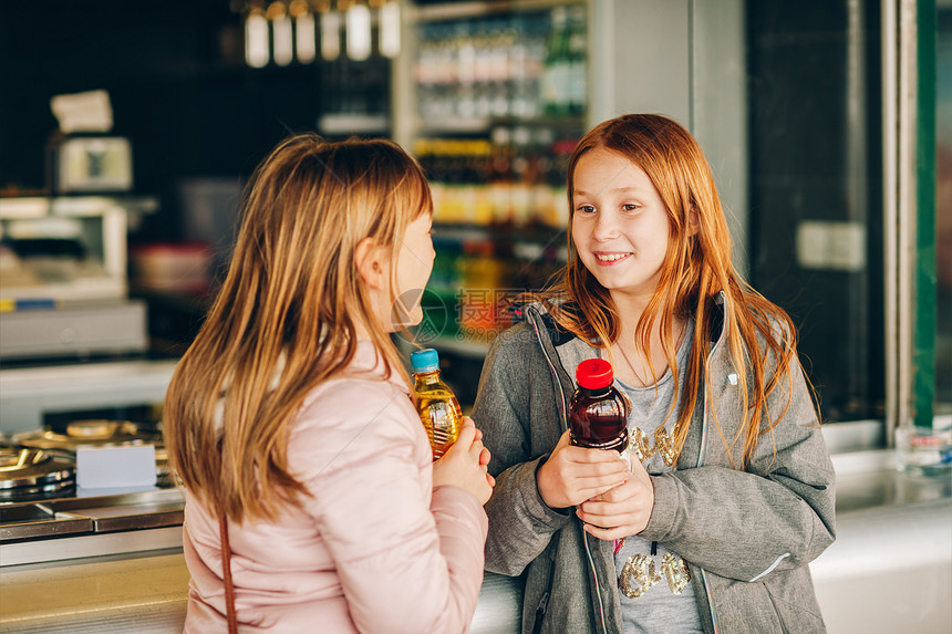 两个小女孩在塑料瓶里买酒图片