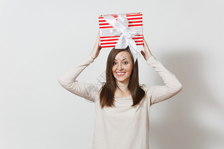 有趣的女人举着头顶红色条纹的礼物盒图片
