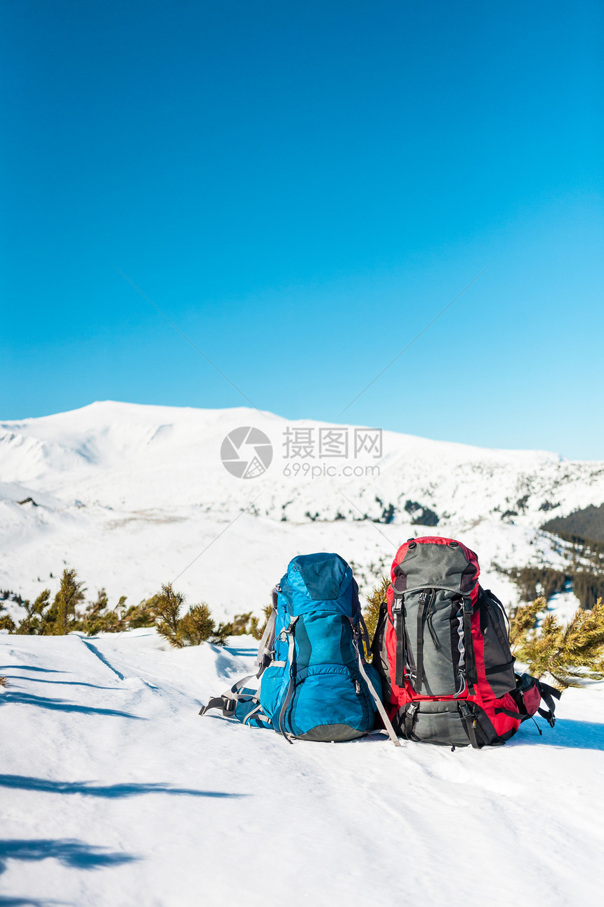 两个背包在雪山和蓝天的背景下雪地上的背包积极的生活方图片