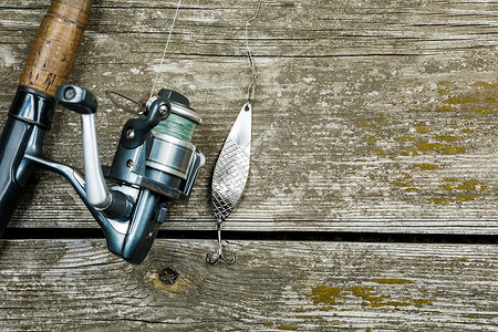 木制背景上的渔具鱼钩和诱饵图片