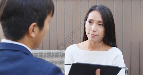 商人与显示平板电脑的女人交谈图片