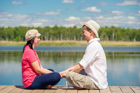 一位年轻的妻子和丈夫在湖边的木图片