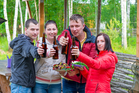 年轻朋友在野外餐时的大自然和香烤肉串和啤酒一图片