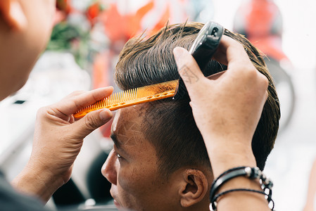 发型师为男客户做时尚发型理发师用电动图片
