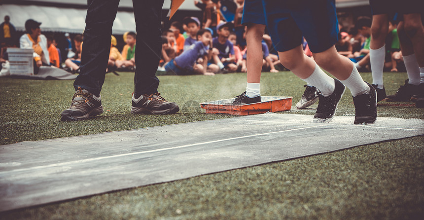 学生男孩在学校体育比赛日在橡胶板上跳远学校运动日比赛活图片