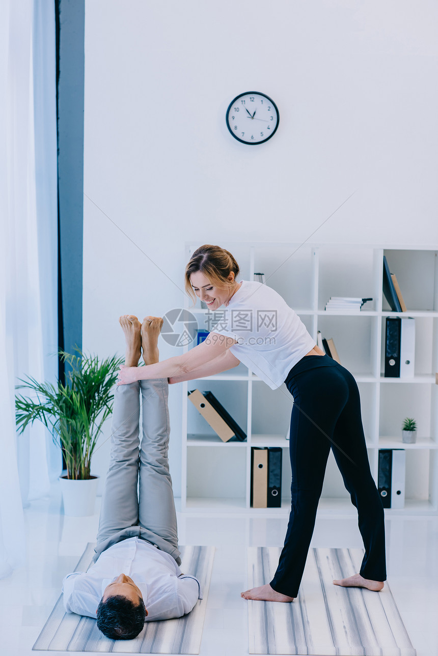 商人和他的教练瑜伽在办公室的图片