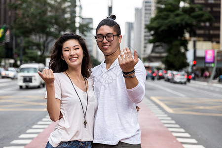 年轻的亚洲夫妇邀请某人来图片