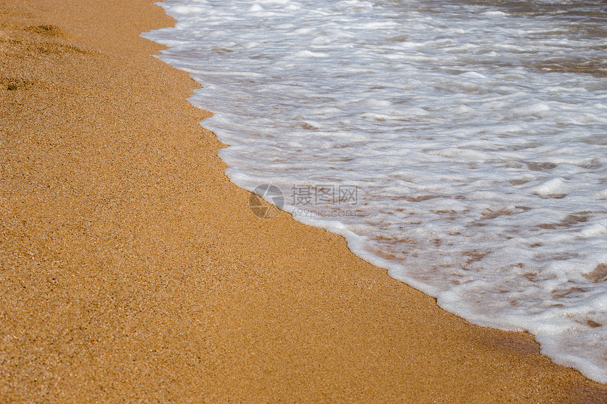 海滩度假和旅游的概念海浪的背景特写镜头与黄色沙滩上的泡沫在西图片