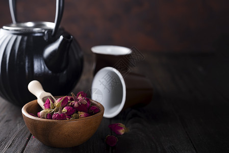 木碗上的玫瑰芽茶和深木背景的茶背景
