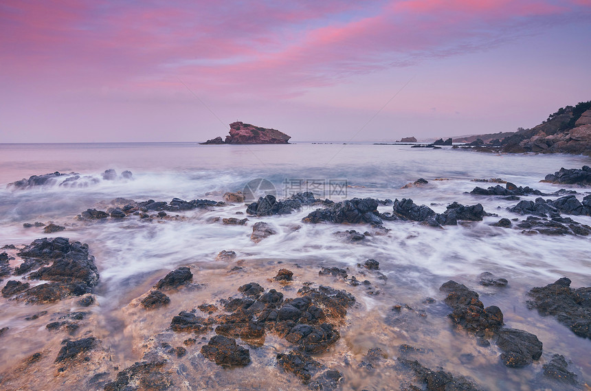 岩石海岸的光辉美丽日落长期图片