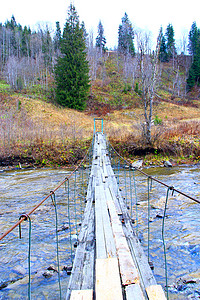 横跨山区河流的绳索上的木桥脚下流动的水图片