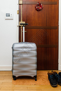 旅行箱公文包行李放在木门前图片