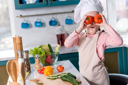 厨帽和围裙上可爱的孩子在厨房做饭图片